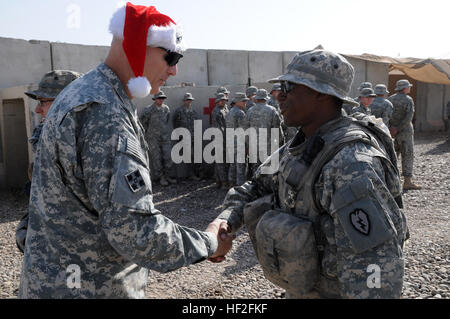 Le général Ray Odierno, Multi-National Force-Iraq commandant général, souhaite un joyeux Noël à la CPS. Ramon Alcantara, opérateur radio téléphone pour la Compagnie Alpha, 1er Bataillon, 21e Régiment d'infanterie, 25e Division d'infanterie, au cours d'une visite au poste de combat Agur Quf, l'Iraq, le Jour de Noël. (Photo de la CPS de l'armée américaine. Kimberly Millett, MNF-I) Affaires publiques Forces multinationales - l'Iraq du Groupe de commande visite les militaires le jour de Noël DVIDS138323 Banque D'Images