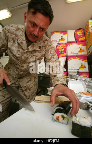 Défonceuse CAMP, l'Iraq- Sergent Alejandro Castellano, le chef de l'entretien des services publics pour le 1er Bataillon du Régiment du génie civil, l'Équipe de Combat 8, inspecte son découpage d'un rouleau de sushi, un des nombreux qu'il a créée pour ses marins, ici. Né au Chili, d'origine italienne et a grandi dans la région de Fairfax, en Virginie, Castellano a acquis beaucoup de recettes tout au long de sa vie qu'il s'ajuste pour faire des créations uniques. Marine Corps officiel (photo par le Cpl. Eric C. Schwartz) USMC-090208-M-5936S-005 Banque D'Images