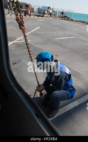 Un membre d'équipage de la Marine royale britannique obtient un UH-60 Black Hawk après l'atterrissage dans le poste de pilotage de la Royal Fleet Auxiliary Baie de Lyme sur le golfe Persique, le 22 octobre 2014. Avant de sortir les passagers et de l'avitaillement, l'hélicoptère, le faucon noir doit être attaché sur le poste de pilotage. (Minnesota Army National Guard photo de la CPS. Jess Nemec/libérés) qualification appontage 141022-Z-OX391-395 Banque D'Images