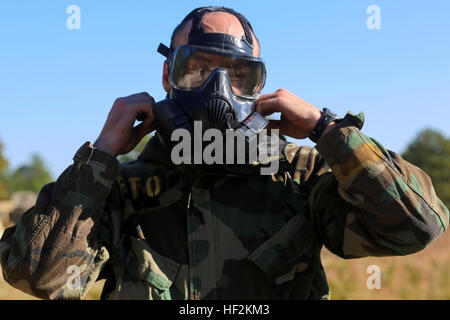 Un 10e Régiment de Marines avec Marine, 2e Division de marines, enfile son masque à gaz et axé sur la mission pour la posture de protection biologique et chimique de la réaction d'armes pendant l'Exercice Rolling Thunder à Fort Bragg, N.C., 26 octobre, 2014. La formation a été conçue pour donner les Marines la foi dans leur équipement. "Notre capacité de fonctionner dans un environnement contaminé, de-contaminer notre équipement et nous-mêmes, puis passer à autre chose et de continuer à se battre est absolument essentiel", a déclaré le Lieutenant-colonel Todd Sermarini, directeur général du 10ème Marines, et Toms River, N.J., les autochtones. Rolling Thunder est un bi-annuel Banque D'Images