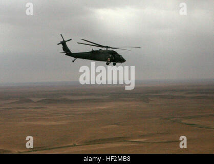 Comme le soleil commence à se coucher sur le désert irakien, le chef d'un UH-60 Blackhawk hélicoptère vol à deux vitesses de vol vers Al Asad Air Base au cours d'un vol d'administration, le 23 février. Des soldats de la Compagnie C, 2e bataillon du 211e Régiment d'aviation, de l'appui général, bataillon de l'Air Air Ambulance, transport régulièrement et non des fournitures de l'état d'urgence d'une base d'opérations à un autre dans la province d'Al Anbar lorsqu'ils ne répondent pas à un appel d'urgence d'évacuation médicale. Air Ambulance en veille tout au long de la province d'Anbar DVIDS AL160418 Banque D'Images