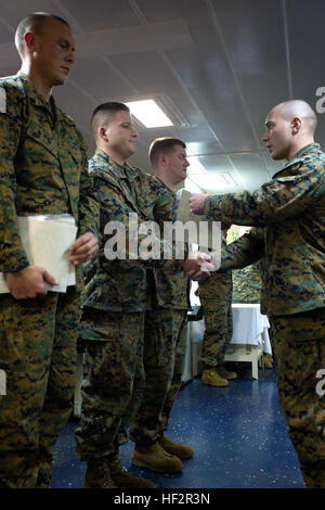 Le sergent David Blum, à gauche, les mains d'un diplôme d'un diplômé d'un caporal de son leadership et de séminaire sur l'éthique à bord du USS Iwo Jima, en mer, le 20 décembre 2014. Le séminaire, a couru par Équipe de débarquement du bataillon du 3e Bataillon, 6e Régiment de Marines, 24e Marine Expeditionary, a été conçu pour fournir des conseils et de l'instruction de jeunes marines comme un tremplin pour leur prochain grade de sous-officier. Le séminaire est prévu pour devenir une condition préalable à la promotion de l'année financière suivante. La 24e MEU déployés la semaine dernière pour un déploiement de sept mois. (U.S. Marine Corps photo par Lance Cpl. Austin A. Lewi Banque D'Images