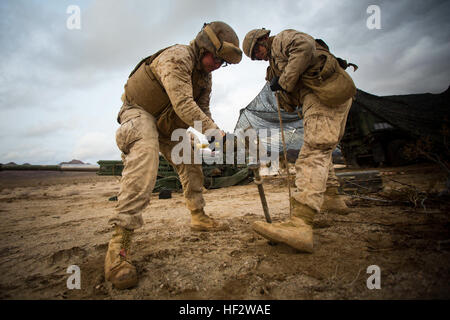 Corps des Marines des États-Unis Le Cpl. Seth M. Selvidge (à gauche), et le Cpl. Frank T. Esparza (à droite) avec batterie Alpha, 1er Bataillon, 12e de marine (1/12), actuellement affecté à 3/12, livre dans les pieux de fixer solidement filet de camouflage au cours de l'exercice de formation intégrée (ITX) 2-15 à la zone d'entraînement à bord Blacktop Camp Wilson, Marine Corps Air Ground Combat Center Twentynine Palms, Californie, Janvier 30th, 2015. L'ITX 2-15, exécuté par les marins à des fins spéciales (Groupe de travail 4 SPMAGTF-4), est menée pour améliorer l'intégration et la capacité de combat de tous les éléments de la MAGTF. (U.S. Marine Co Banque D'Images