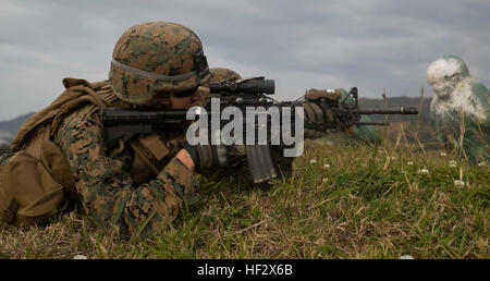 Le Cpl. Sean Harmon, de Brockton, Massachusetts, tire sa M4A1 carabine de service à une cible lors d'un incendie réel plage de distance inconnue 7 février sur Camp Hansen. Les Marines "buddy" se sont précipités à travers les collines et vallées tandis que le tir sur des cibles qui apparaissent au hasard des distances. Buddy se précipitant est lorsque deux ou plusieurs marines offrent une couverture pour chaque feu d'autres en se dépêchant vers l'objectif. Harmon est un missile antichar-man Company W, bataillon de l'équipe d'atterrissage 2e Bataillon, 4e Régiment de Marines actuellement affectés à la 31e unité expéditionnaire de Marines. (U.S. Marine Corps photo par le Cpl. Tindle Devon Banque D'Images