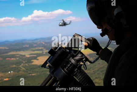 Le sergent du Corps des Marines des États-Unis. Benjamin Hebert, un Huey UH-1Y, chef d'équipe s'apprête à congédier le GAU-17/une mitrailleuse Gatling 27 février lors d'un événement de coopération en matière de sécurité dans le théâtre. Les Marines américains a accueilli l'événement pour les membres des Forces armées malaisiennes et les civils. Hebert est de Bothell, Washington, et est à l'escadron 262 à rotors basculants moyen maritime (renforcée), 31e Marine Expeditionary Unit. La 31e MEU est le seul de l'avant sans cesse déployés MEU et est en train d'effectuer une patrouille de printemps 2015 de la région Asie-Pacifique. (U.S. Marine Corps photo par le Cpl. Perria abbaye/libérés) capacités US Marines montrent t Banque D'Images