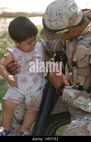 Un soldat irakien avec la 6e armée iraquienne divertit un enfant irakien avec un jeu de clés à Abu Ghraib, en Irak, le 10 juin. Flickr - DVIDSHUB - Patrouille à Abou Ghraib Banque D'Images