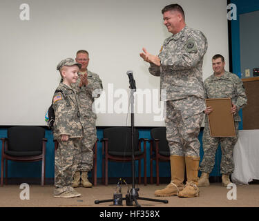 Le brig. Gen Sean Ryan, droite, Commandant, 71e commandement de troupes, Texas Army National Guard, commande le Sgt. Le Major Mark A. Weedon, Texas Senior Conseiller des forces militaires enrôlés, à gauche, et Sgt. David Hixson, infirmier de la 1ère Escadrille, 112e régiment de cavalerie, Rowan Bienvenue sur Texas Windham Army National Guard à son enrôlement à l'honneur cérémonie tenue au Camp Mabry à Austin, Texas, le 27 mars 2015. Windham se bat contre une maladie rare, le syndrome d'Shwachmann-Diamond, qui affecte le pancréas, du tractus gastro-intestinal, le système immunitaire, le sang et la moelle osseuse. Lors de l'un de ses séjours à l'Hôpital pour enfants Banque D'Images