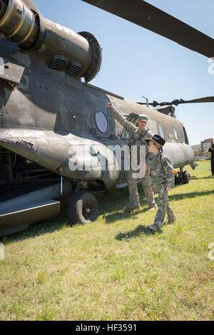 Enlistee honoraire Rowan Windham obtient une visite de CH-47 Chinook par le sergent. Clay Jenkins, mécanicien de bord de la 2e Bataillon, 149e Régiment d'aviation, Texas Army National Guard. Windham était honorarily s'enrôle dans la Garde nationale du Texas lors d'une cérémonie tenue au Camp Mabry à Austin, Texas, le 27 mars 2015. Windham se bat contre une maladie rare, le syndrome d'Shwachmann-Diamond, qui affecte le pancréas, du tractus gastro-intestinal, le système immunitaire, le sang et la moelle osseuse. Lors de l'un de ses séjours à l'Hôpital pour enfants de San Antonio, Windham a rencontré le sergent. David Hixson, infirmier de l'armée du Texas Banque D'Images