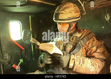 Le Lieutenant-colonel de l'armée britannique Adam Griffiths, commandant du 5e Bataillon du Régiment Royal d'Écosse, lit un livre, alors qu'il était assis à l'arrière d'un véhicule de patrouille protégé de Mastiff en voyageant à Lashkar Gah, dans la province d'Helmand, en Afghanistan, le 2 avril. Griffiths a atteint la fin d'un déploiement de sept mois dont il a dirigé la Police de Helmand Task Force d'encadrement et de conseil du groupe. Chef de l'Équipe spéciale HelmandE s28099d'encadrement et de conseil de la police groupe reflète le travail bien fait 110402-M-PH073-006 Banque D'Images