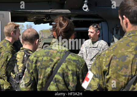 Le sergent de la Garde nationale de l'Armée de l'Oregon. Michael Buchan (centre), un vol infirmier de la Compagnie Charlie, 7-158 Aviation, explique les procédures d'évacuation médicale pour le HH-60M Black Hawk aux membres des Forces armées canadiennes au cours de l'exercice Maple Résoudre 2015 à la Base des Forces canadiennes Wainright, le 11 mai, à Denwood (Alberta). L'Oregon medevac Army National Guard est l'unité de soutien des forces armées canadiennes au cours de l'exercice annuel le plus important. (Photo par le Sgt. Erin J. Quirke, 41ème Infantry Brigade Combat Team) Affaires publiques Oregon medevac Army National Guard de trains avec des forces armées canadiennes pendant Banque D'Images