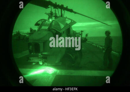 La Marine américaine lance le Cpl. James R. Shugart (à gauche) et le Cpl. Kyle C. Lyons (à droite), la mécanique de l'hélicoptère avec l'équipe de nuit, les moyennes de l'escadron à rotors basculants (VMM) 162 (renforcée), 26e Marine Expeditionary Unit (MEU), signal pour le pilote et co-pilote d'un AH-1 Cobra Super de démarrer les moteurs pour une vérification de l'entretien pré-vol avant le décollage lors d'un groupe Amphibie/Marine Expeditionary Unit Exercise (ARG/MEU-Ex) à bord de l'USS Kearsarge, 25 juin, 2015. Le 26e Escadron amphibie et MEU 4 mènent une ARG/MEU-Ex en prévision de leur déploiement à la 5ème et la 6ème flotte sont Banque D'Images