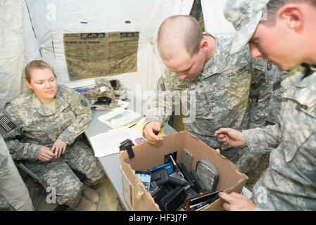 Pvt. Jacklin Cleveland, un spécialiste de l'approvisionnement de l'unité 92Y, vérifie les soldats et leurs téléphones cellulaires dans la 116e Brigade Combat Team de cavalerie, Texas Army National Guard's Centre des opérations tactiques (COT) au Centre National d'entraînement, Fort Irwin, en Californie, le 12 août. Les téléphones cellulaires sont limités dans la TABLE DES MATIÈRES afin d'assurer la sécurité opérationnelle. (Photo par le major W. Chris Clyne, Mobile 115e Détachement des affaires publiques, de l'Oregon Army National Guard) 116th Cavalry Brigade Combat Team travaille jour et nuit à l'entraînement 150812-Z-ZJ128-006 Banque D'Images