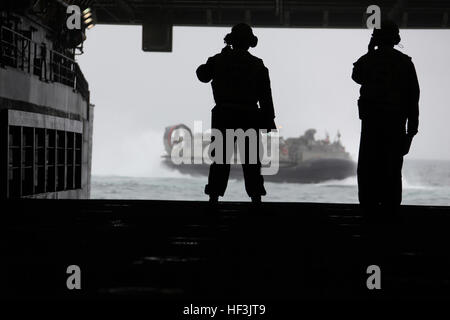 Deux Marines du Combat Cargo, USS New York attendre comme un landing craft air cushioned embarque le navire au large de la côte de Marine Corps Base Camp Lejeune, N.C., le 30 octobre 2009. À bord du navire sont marines à partir de plusieurs unités qui ont fusionné pour former la masse d'Air Maritime à des fins spéciales 26 Groupe de travail pour la mise en service du navire à New York, le 7 novembre. (Photo de l'USMC Officiel Lance Cpl. Tommy Bellegarde) (Publié) LPD-21 pont du coffre Banque D'Images