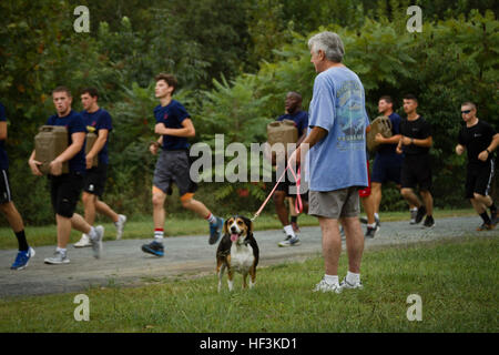 Un homme promenait son chien montres en tant que membres de l'entrée retardée du Marine Corps d'exécuter un programme de trois milles à la randonnée logistique Zoo de Salisbury de Salisbury, Maryland, le 12 septembre 2015. Environ 30 recrues du Corps des Marines, aussi connu comme poolees, a participé à la randonnée pédestre, qui a été conçu pour les contester physiquement et d'établir de bons avant d'assister à l'instruction des recrues à Marine Corps Recruter Depot Parris Island, Caroline du Sud plus tard cette année. (U.S. Marine Corps photo par le Sgt. Bryan Nygaard/libérés) Marine recrues apprennent le travail d'équipe au cours de la randonnée épuisante 150912-M-PH073-088 Banque D'Images