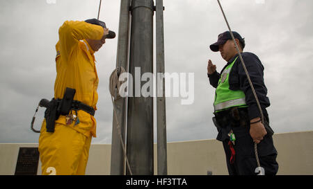 Les agents de sécurité japonais salute comme Kimi Ga Yo, l'hymne national japonais, Mars 11 Camp à bord de Foster, Okinawa, Japon. Les drapeaux sont mis en berne en souvenir du cinquième anniversaire du grand tremblement de terre de Tohoku. Le tremblement de terre de magnitude 9,0 a provoqué des vagues de tsunami jusqu'à 13 étages de haut et conduit à la catastrophe nucléaire de Fukushima. Les drapeaux américains et japonais voler côte à côte en berne 11 mars Camp à bord de Foster, Okinawa, Japon. Les drapeaux sont mis en berne en souvenir du cinquième anniversaire du grand tremblement de terre de Tohoku. Le tremblement de terre de magnitude 9,0 ca Banque D'Images