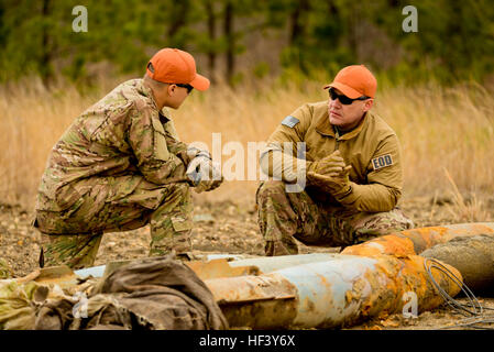 À partir de la droite, le sergent-chef de l'US Air Force. Raymond Wayne, des explosifs et munitions (NEM) Technicien à la New Jersey Air National Guard's 177e Escadre de chasse, et d'un membre de la 1re classe Michael Glisan, l'extension de la technologie avec le 87e Escadron de génie civil, Joint Base McGuire-Dix-Lakehurst, discuter par-le-livre techniques d'empilage triple C-4 sur les explosifs utilisés bombes pratique pour les rendre sécuritaires pour le recyclage à Warren Grove en gamme Ocean Comté, N.J. le 29 avril 2016. Les membres de NEM, les ingénieurs civils et la gamme crew ont travaillé ensemble pendant la semaine annuelle à l'EOD 'gamme' pour effectuer le nettoyage et la plage Banque D'Images