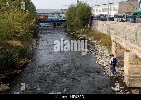 Osh, au Kirghizistan - Octobre 05, 2014 : un pêcheur La pêche dans une rivière de la ville kirghize Osh Banque D'Images