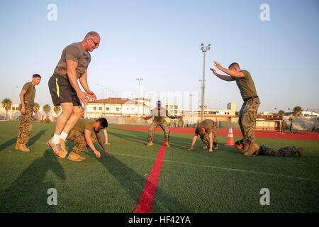 Le célèbre Chef Robert Irvine et les Marines avec des air-sol marin crise Response-Africa Task Force conduite burpees lors d'un événement d'entraînement physique à la base aéronavale de Sigonella, en Italie, le 28 juillet 2016. Marines a terminé un cours de circuit avec Irvine, qui comprenait le haut et le bas du corps d'entraînement, Marine Corps techniques Programme d'arts martiaux et tours autour du terrain de baseball. (U.S. Marine Corps photo par le Cpl. Alexander Mitchell/libérés) Chef Robert Irvine passe du temps avec les Marines en Italie 160728-M-ML847-247 Banque D'Images