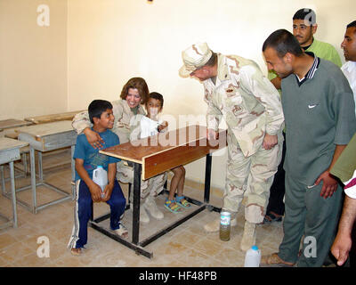 030424-M-8658H-003 Umm Qasr, le Koweït (avr. 24, 2003) -- Adm arrière. Charles Kubik, commandant de la Première Division de la construction navale, parle de deux garçons irakiens sur le nouveau Umm Qasr vient juste de rouvrir l'école secondaire, avec l'aide d'un traducteur. Les Seabees reconstruit l'école secondaire alors que dans le cadre de l'opération Iraqi Freedom. L'opération Iraqi Freedom est l'effort de la coalition pour libérer le peuple irakien, d'éliminer les armes de destruction massive de l'Iraq et de mettre fin au régime de Saddam Hussein. U.S. Marine Corps photo par le major Kathleen A. Hoard. (Libéré) US Navy 030424-M-8658H-003 SMA arrière. Ch Banque D'Images