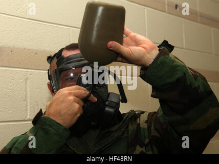 Le colonel Eric J. 22e Marine Expeditionary vécu, commandant de l'unité, et de Denver, natif de boissons d'une cantine à l'aide du tube potable attaché à la zone M-50 nouvellement émises au cours du masque de protection annuelle du MEU-chambre à gaz à bord formation Camp Lejeune, en Caroline du Nord, le 27 août, 2010. Le M-50's système potable améliorée permet un meilleur écoulement de l'eau que son prédécesseur, le M-40. L'IP a été le premier grand commandement subalterne dans le Corps des marines sur la côte est de recevoir le nouveau masque à gaz M-50 pour la formation. La formation est destinée à renforcer la confiance dans le masque et s'assurer que les Marines connaissent la prop Banque D'Images