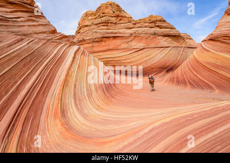 Balade dans la vague - Un randonneur bien équipé de marcher à travers le centre de l'onde sur une journée de printemps ensoleillée. Arizona-Utah, USA. Banque D'Images