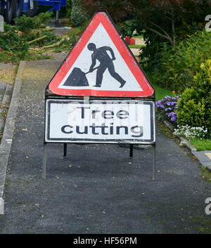 Plaque de signalisation triangulaire placé sur la chaussée indiquant l'homme au travail la coupe d'arbres Banque D'Images