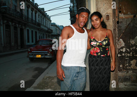 Jeune couple et voiture d'époque à l'arrière-plan, La Havane, Cuba, Caraïbes, Amériques Banque D'Images