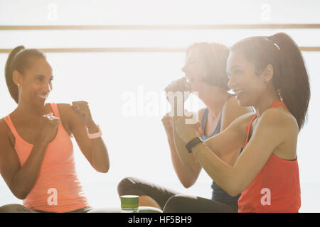 Les femmes faisant des gestes avec les poings en classe d'exercice fitness studio Banque D'Images
