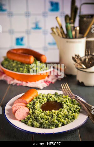 Une cuisine rustique avec une plaque avec 'Boerenkool rencontré pire' ou le chou frisé avec saucisse fumée, un repas traditionnel néerlandais. Servi avec de la sauce. Typiquement Hollandais avec Banque D'Images