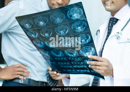 Closeup portrait de professionnels de la santé intellectuelle avec blanc labcoat, à tout le corps à l'image radiographique (rayons x, tomodensitométrie, IRM, isolé ho Banque D'Images