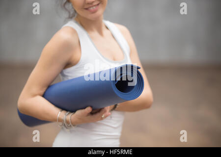 Happy Yogi woman holding her mat, Close up Banque D'Images