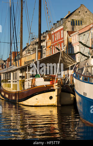 Danemark, copenhague, Nyhavn, bateaux amarrés à côté d'entrepôts quai convertis en logements et restaurants du canal de visites en bateau Banque D'Images