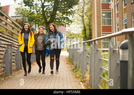 L'enseignement supérieur au Royaume-Uni : Trois happy smiling rire Aberystwyth University Women Femmes marchant à leurs conférences sur le campus Banque D'Images