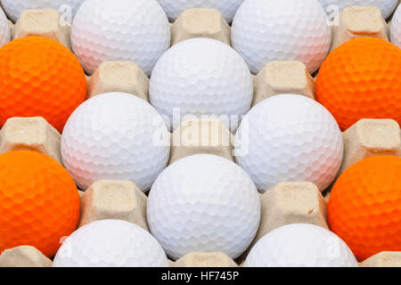 Balles de golf blanc et orange dans la boîte pour les oeufs Banque D'Images