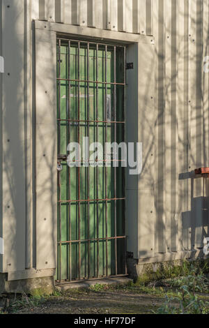 En lieu clos et de sécurité porte cadenassée d'un atelier sur une zone industrielle. Barrière de sécurité la métaphore. L'obstruction ou l'obstruction du concept. Banque D'Images