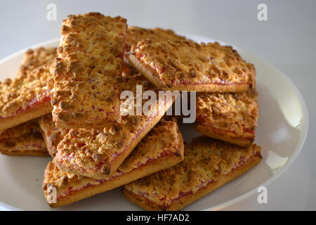 Des biscuits avec de la confiture de fraise sur une plaque blanche Banque D'Images