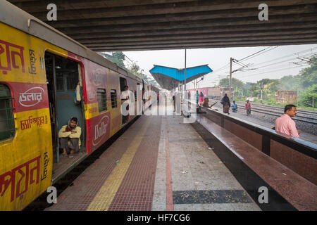 Train local de passagers de l'Indian Railways debout à une gare ferroviaire sur un matin d'hiver brumeux. Banque D'Images