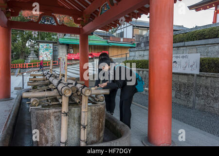 La purification rituelle tsukubai au Sanctuaire Fushimi Inari Taisha Temple Shintoïste, Kyoto, Japon Banque D'Images