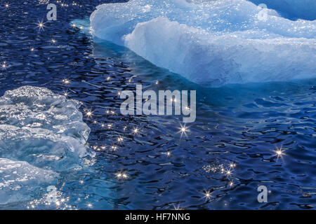 Des morceaux de la dérive des icebergs bleu et soleil sur la surface de l'eau scintillante, Groenland Banque D'Images