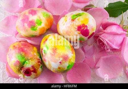 Oeufs de Pâques peints placés sur les pétales de rose Banque D'Images