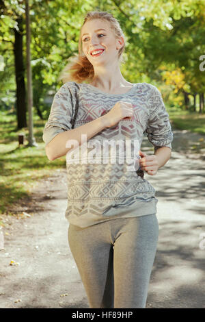 Jeune fille aux yeux bleus un joging dans le parc Banque D'Images