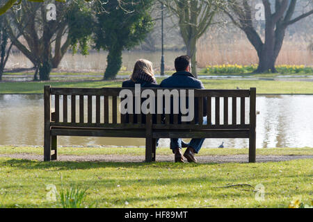 Couple assis sur banc avec vue sur la rivière Ouse qui a inondé ses rives à Bedford, Bedfordshire, Angleterre Banque D'Images