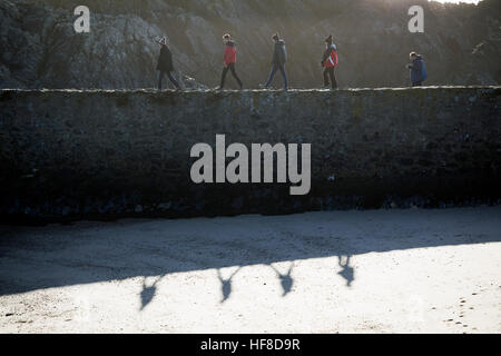 Les visiteurs de l'île Llanddwyn au large de la côte d'Anglesey bénéficiant des conditions agréables comme ils marchent à travers la digue du port Banque D'Images