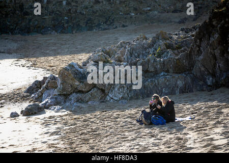 L''Anglesey, au Pays de Galles, Royaume-Uni conditions calmes à newborough sur la côte ouest d'Anglesey en Galles du nord. Malgré le froid la nuit c'était une journée agréable sur l'île et le rivage. les visiteurs de l'île Llanddwyn de la côte d'Anglesey bénéficiant des conditions agréables avec un spot de déjeuner et vous reposer sur l'une des plages cachées connu sous le nom de Pilot's Cove sur l'île en décembre Banque D'Images