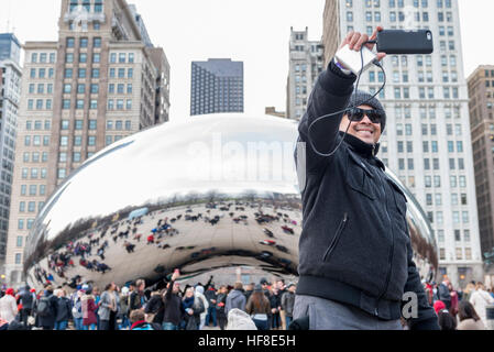 Chicago, USA. 28 décembre 2016. L'hiver exceptionnellement doux met en valeur les touristes sur leur maison de vacances comme ils visitent Cloud Gate, connue localement comme 'Le Bean', une sculpture emblématique centre-ville par l'artiste Anish Kapoor. © Stephen Chung / Alamy Live News Banque D'Images