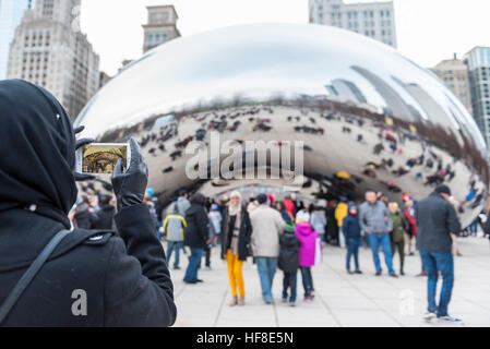 Chicago, USA. 28 décembre 2016. L'hiver exceptionnellement doux met en valeur les touristes sur leur maison de vacances comme ils visitent Cloud Gate, connue localement comme 'Le Bean', une sculpture emblématique centre-ville par l'artiste Anish Kapoor. © Stephen Chung / Alamy Live News Banque D'Images