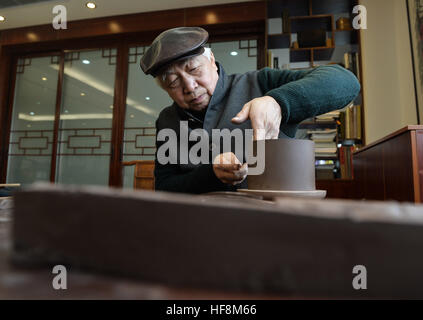 Yixing, Province de Jiangsu. Dec 29, 2016. Shaopei Gu fait une argile Yixing théière dans un studio à Yixing, Province de Jiangsu Chine orientale, le 29 décembre 2016. Gu, un héritier de la technique de Yixing poterie, a fait des théières depuis plus de 50 ans. Il y a 6 587 spécialistes engagés dans la poterie de Yixing, un important centre de production de céramique en Chine. © Ji Chunpeng/Xinhua/Alamy Live News Banque D'Images