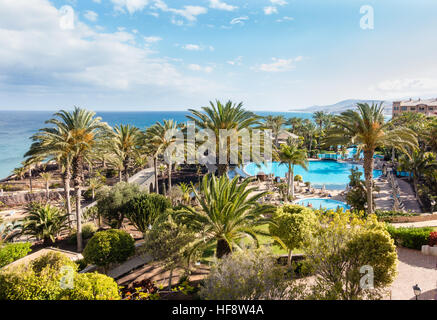 Jardin de l'hôtel avec piscines et palmiers et vue magnifique sur l'océan atlantique avec une ligne de côte de Costa Calma Banque D'Images