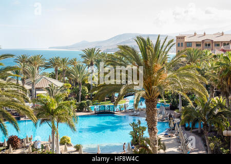 La piscine principale, le bar de la piscine, des palmiers, et vue sur l'océan et sur la côte de Costa Calma Banque D'Images
