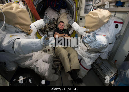 La NASA L'astronaute de l'équipage de l'expédition 49-50 premier American Shane Kimbrough flotte à côté de deux scaphandres américains à l'intérieur du sas Quest de la Station spatiale internationale le 14 décembre 2016 dans l'orbite de la Terre. Banque D'Images